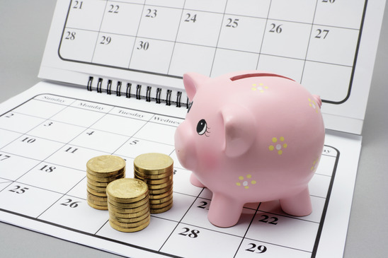 Piggy Bank and Coins on Calendar