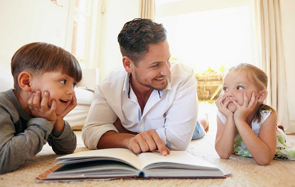 Young man with two kids reading a story book