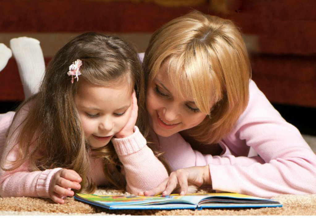 sweet  little girl with mother reading book