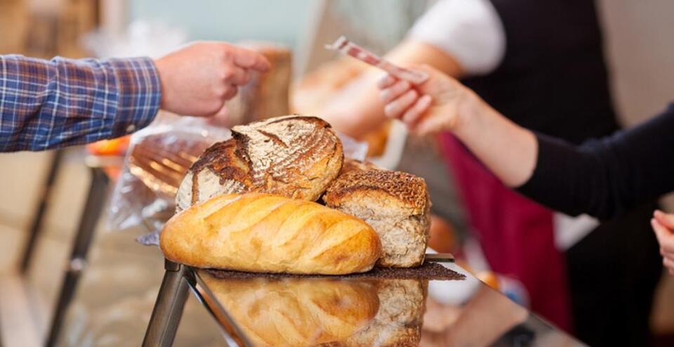 Closeup of customer paying for breads at bakery counter