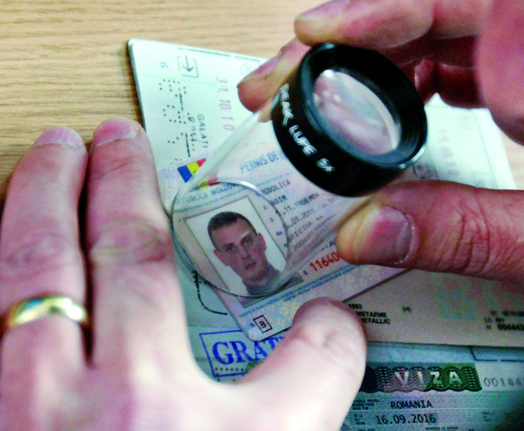 A border policeman checks documents at Romania's eastern border with Moldova which is due to become the new border of the EU passport-free Schengen zone in Giurgiulesti