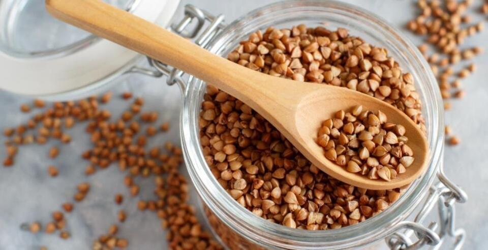 Raw dry buckwheat grain  in a jar with a spoon